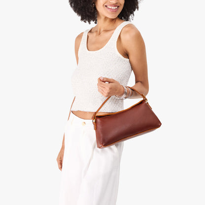 Nutmeg | Model holding a brown colored bowler style hand bag