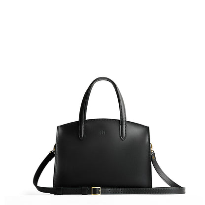 Black*Medium | Leather tote bag with handles, adjustable crossbody strap, zipper top, and two back pockets