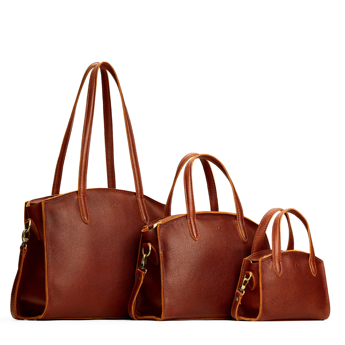Nutmeg | Size comparison image of Mini, Medium, and Large-sized leather tote bags with handles, adjustable crossbody strap, zipper top, and back pockets