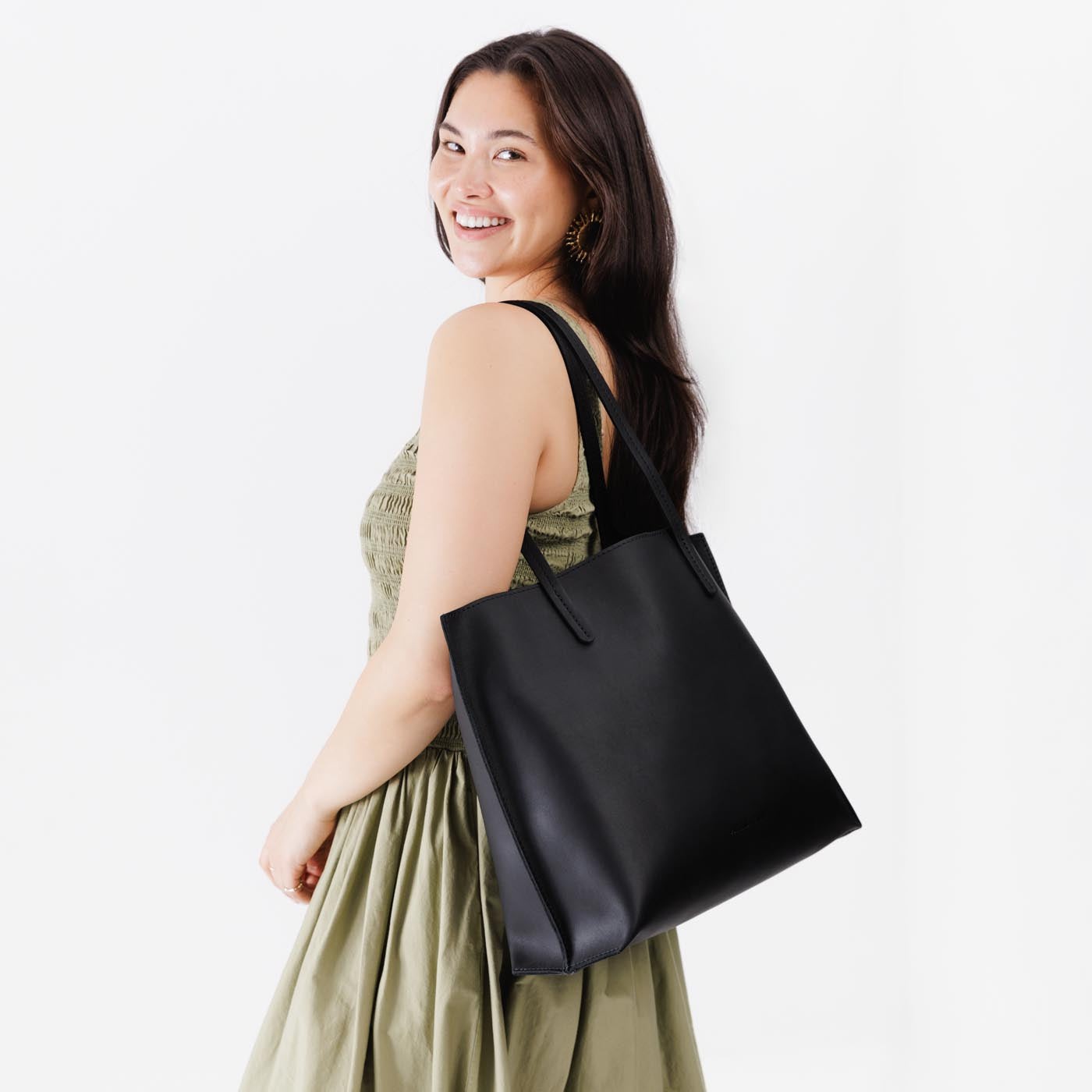 Black*Large | Model holding leather tote bag with interior snap key loop