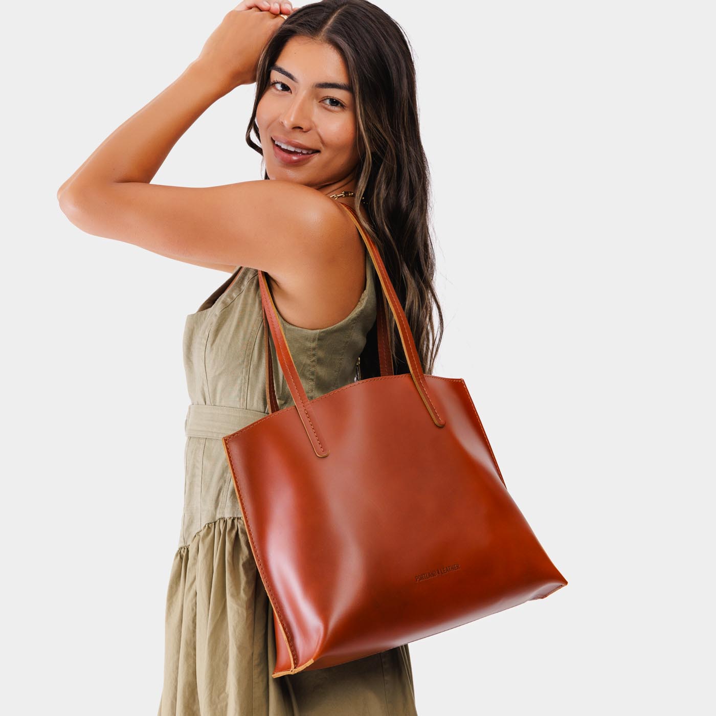 Madrone*Medium | Model holding leather tote bag with interior snap key loop