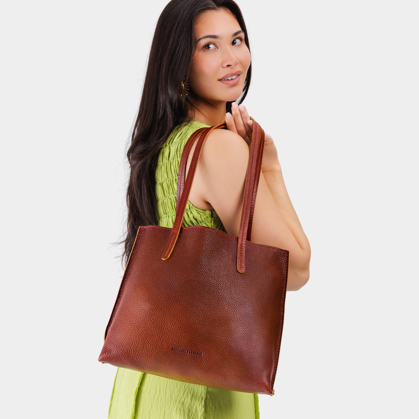 Nutmeg*Medium | Model holding leather tote bag with interior snap key loop VARIANT2