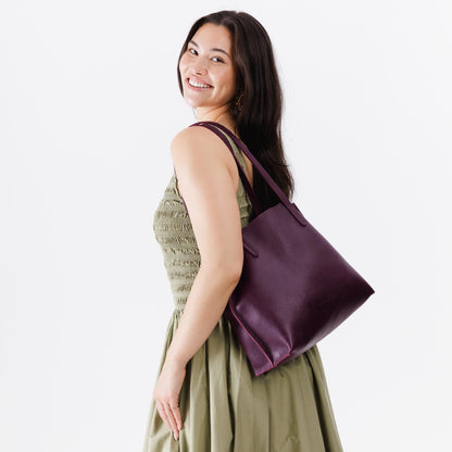 Plum*Medium | Model holding leather tote bag with interior snap key loop