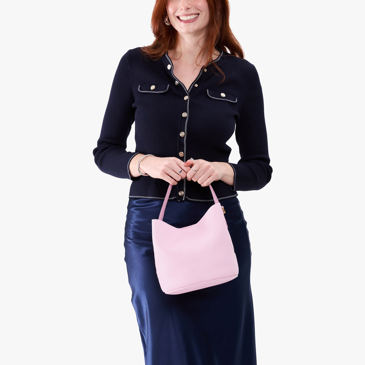 Pinkaboo*Small | Model holding symmetrical bucket bag with handle, latch closure, and removable crossbody strap