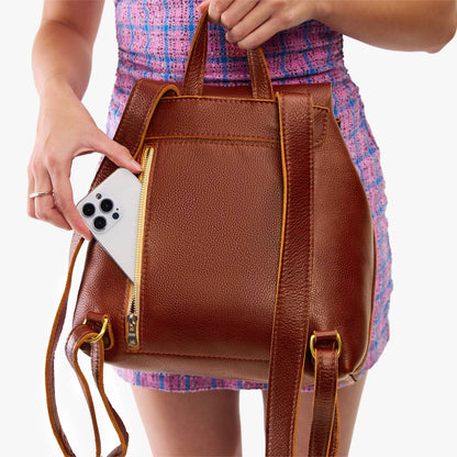 Nutmeg | Model wearing a leather backpack on a white background