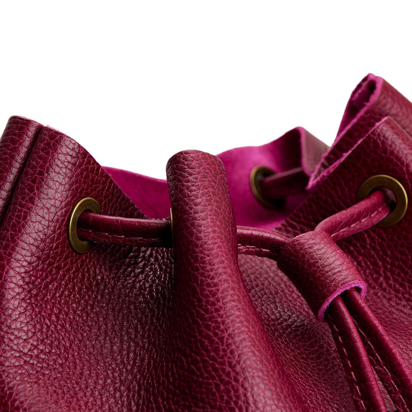 Orchid | Close-up of leather drawstring backpack with grommets.