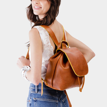 Sienna | Pebbled leather drawstring backpack being worn by a person.