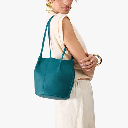 Aquarius*Small | Model wearing matching white shirt and skirt carrying petite bucket shaped tote bag with matching leather handles