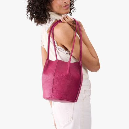 Cosmo*Small | Model wearing matching white sleeveless shirt and pants holding petite bucket shaped tote bag with matching leather handles