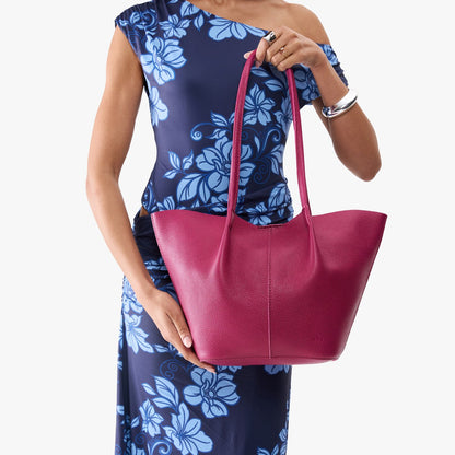 Cosmo*Large | Model wearing blue floral patterned dress holding wide bucket shaped tote bag with matching leather handles