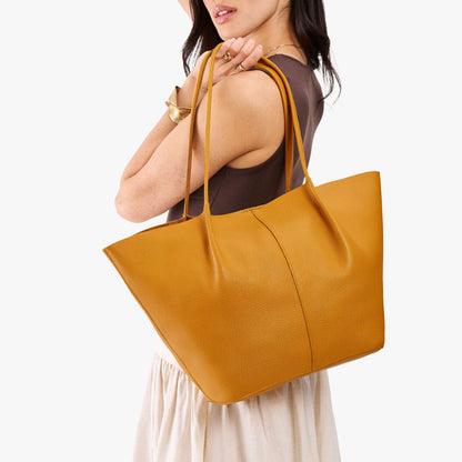 Sunshine*Oversized | Model wearing brown sleeveless top with white skirt carrying extra wide bucket shaped tote bag with matching leather handles