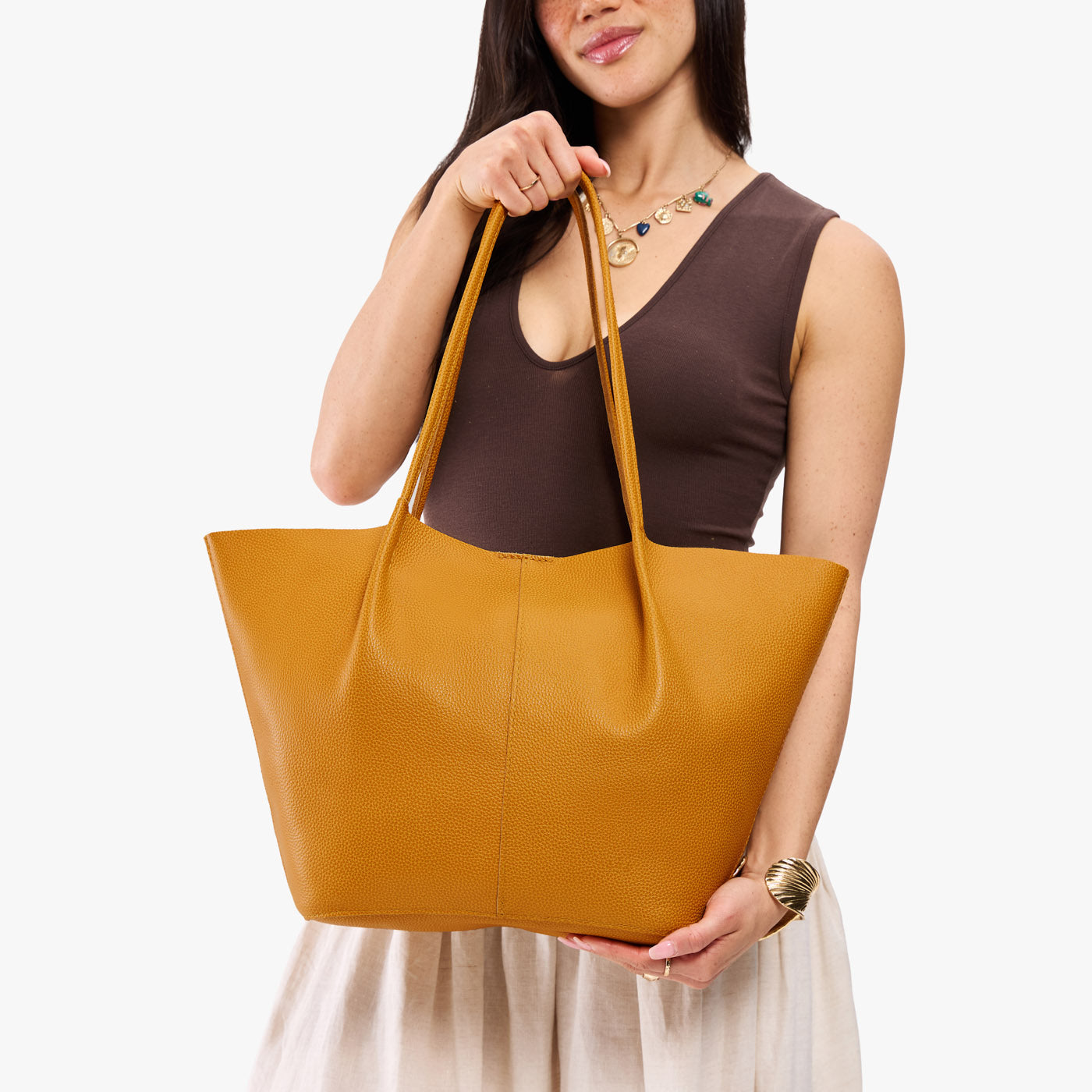 Sunshine*Oversized | Model wearing brown sleeveless top with white skirt holding extra wide bucket shaped tote bag with matching leather handles