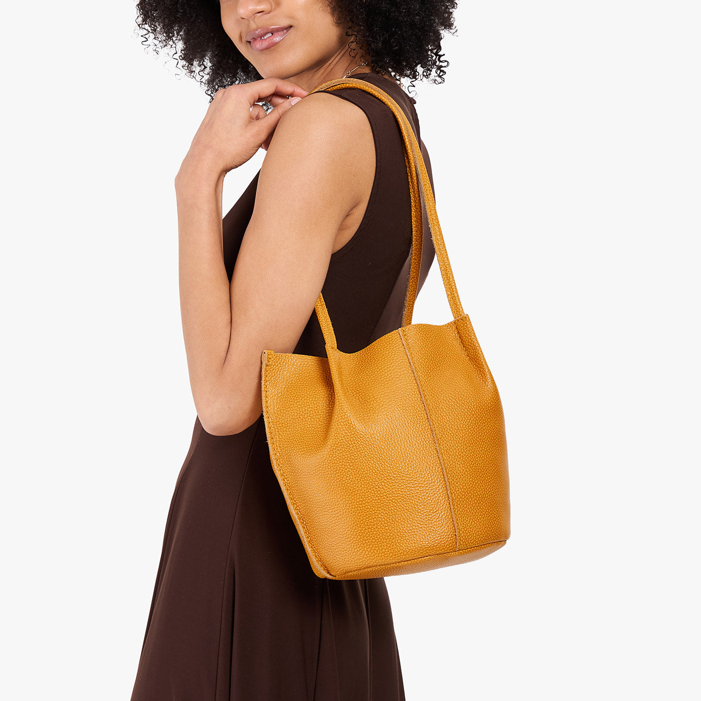 Sunshine*Small | Model wearing dark brown dress carrying petite bucket shaped tote bag with matching leather handles