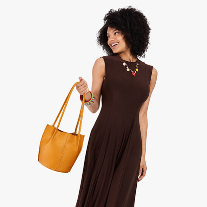 Sunshine*Small | Model wearing dark brown dress holding petite bucket shaped tote bag with matching leather handles