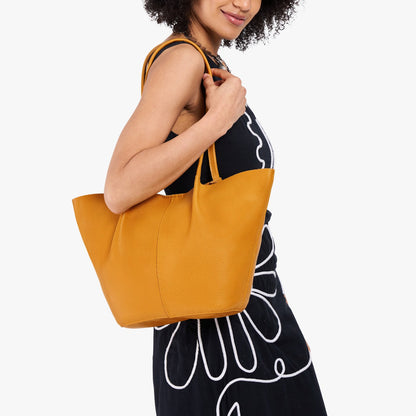 Sunshine*Large | Model wearing black dress and carrying wide bucket shaped tote bag with matching leather handles