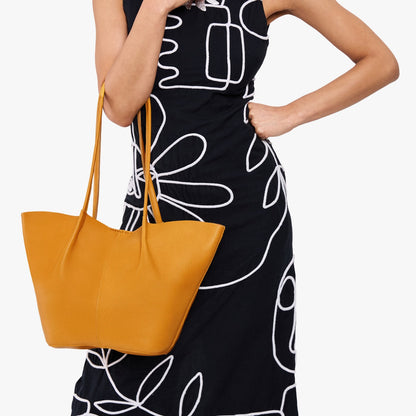 Sunshine*Large | Model wearing black dress and carrying wide bucket shaped tote bag with matching leather handles