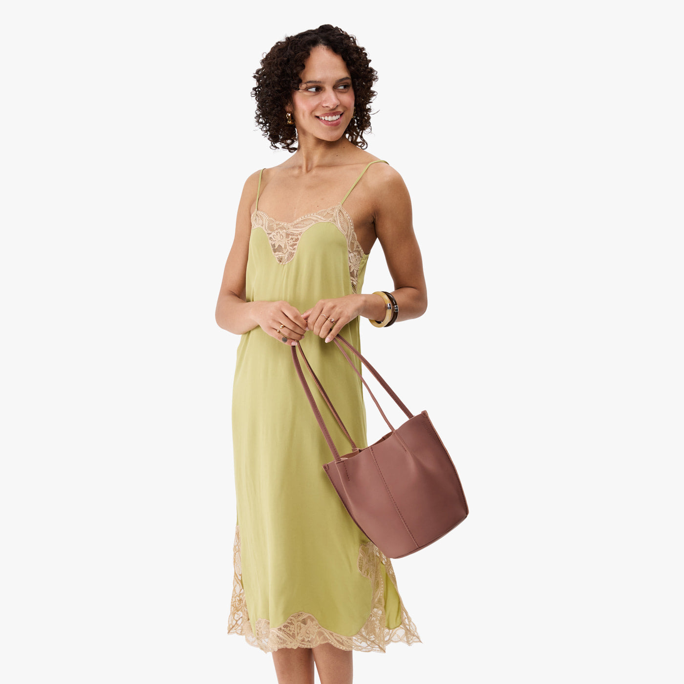 Sunkissed*Small | Model wearing sleeveless light green dress holding petite bucket shaped tote bag with matching leather handles