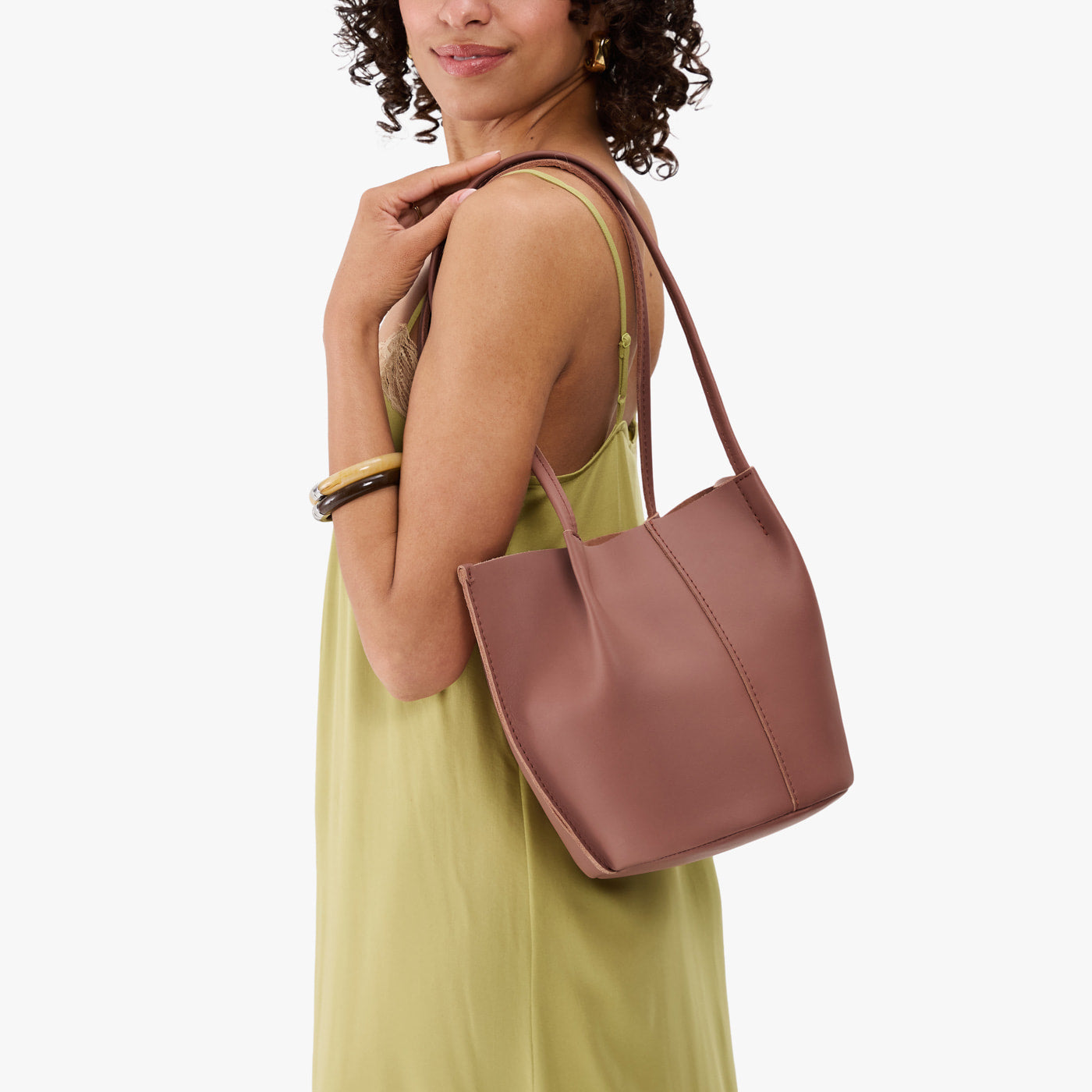 Sunkissed*Small | Model wearing sleeveless light green dress carrying petite bucket shaped tote bag with matching leather handles