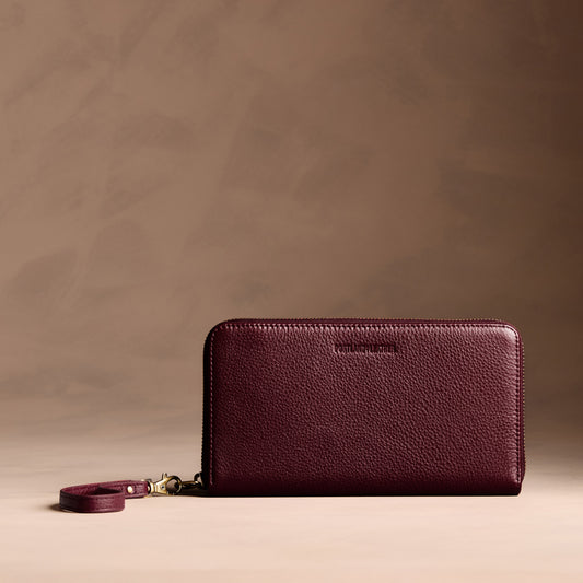 Hunter | Full zip around wallet with a strap on a brown background