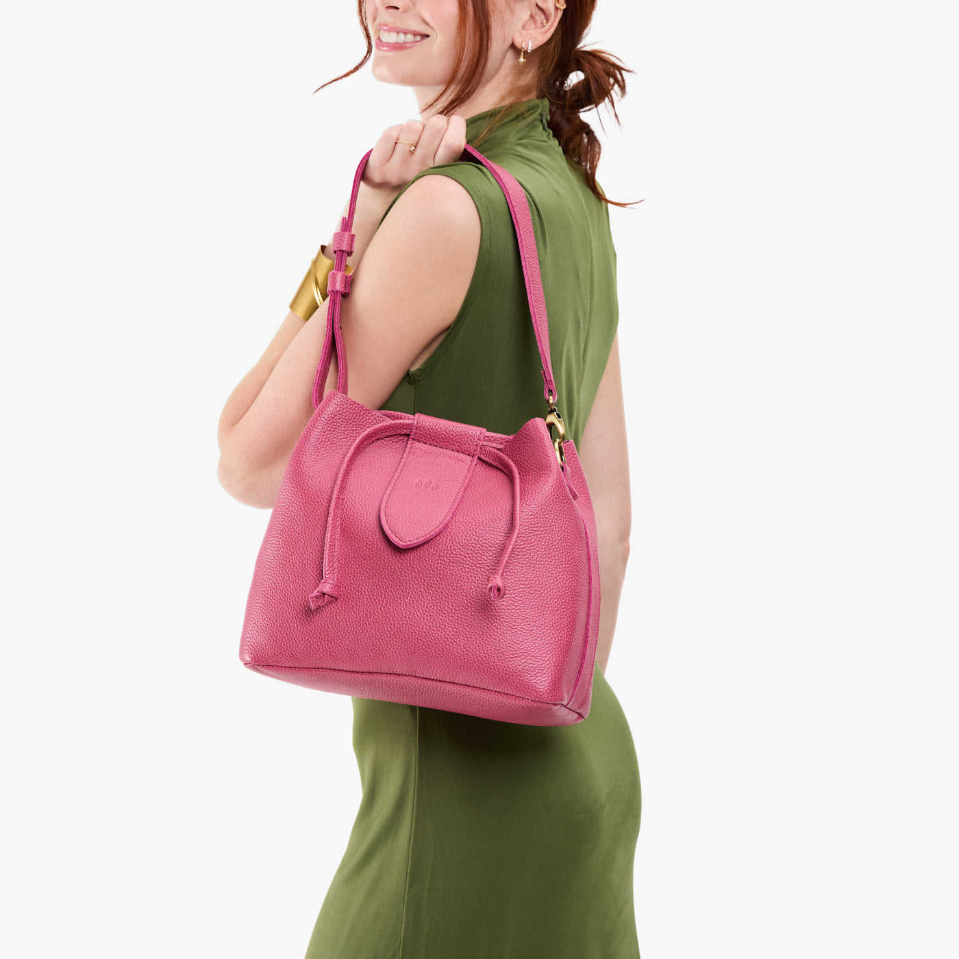 Wild Rose*Large | Model holding symmetrical leather bag with leather drawstring closure and adjustable shoulder strap