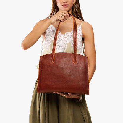 Nutmeg*Large | Model carrying leather tote bag with handles, adjustable crossbody strap, and two back pockets