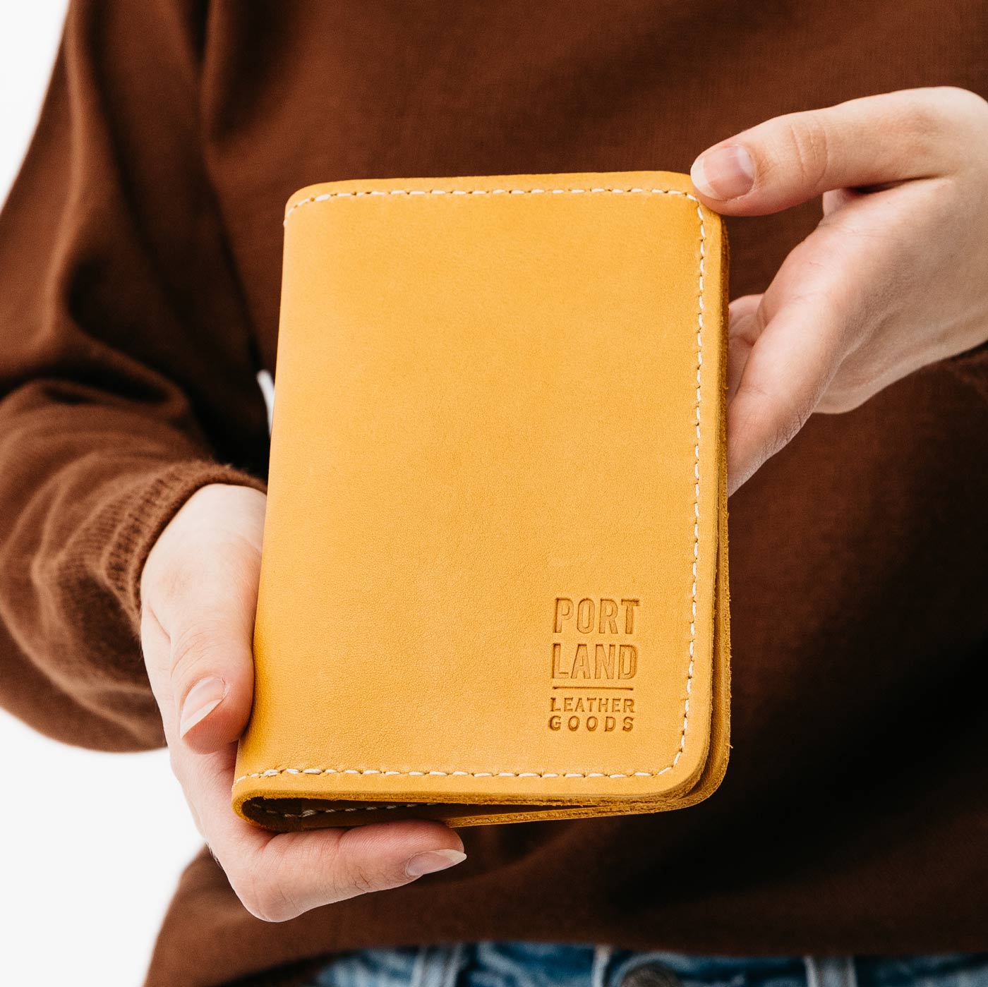 Sunflower | Model holding leather passport case with PLG logo