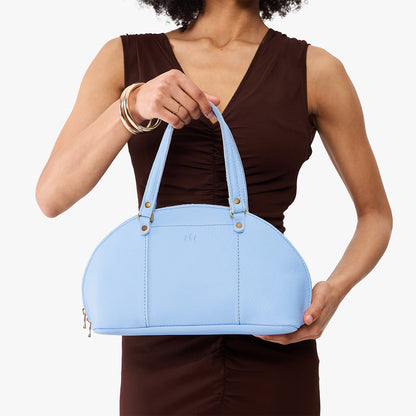 Skyway*Small | Model holding a half circle crossbody bag with handles and removable crossbody strap