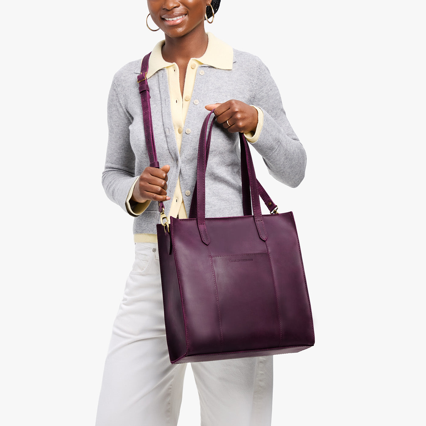 Larkspur*North/South | Model holding structured large tote bag with overlapping panels and crossbody strap