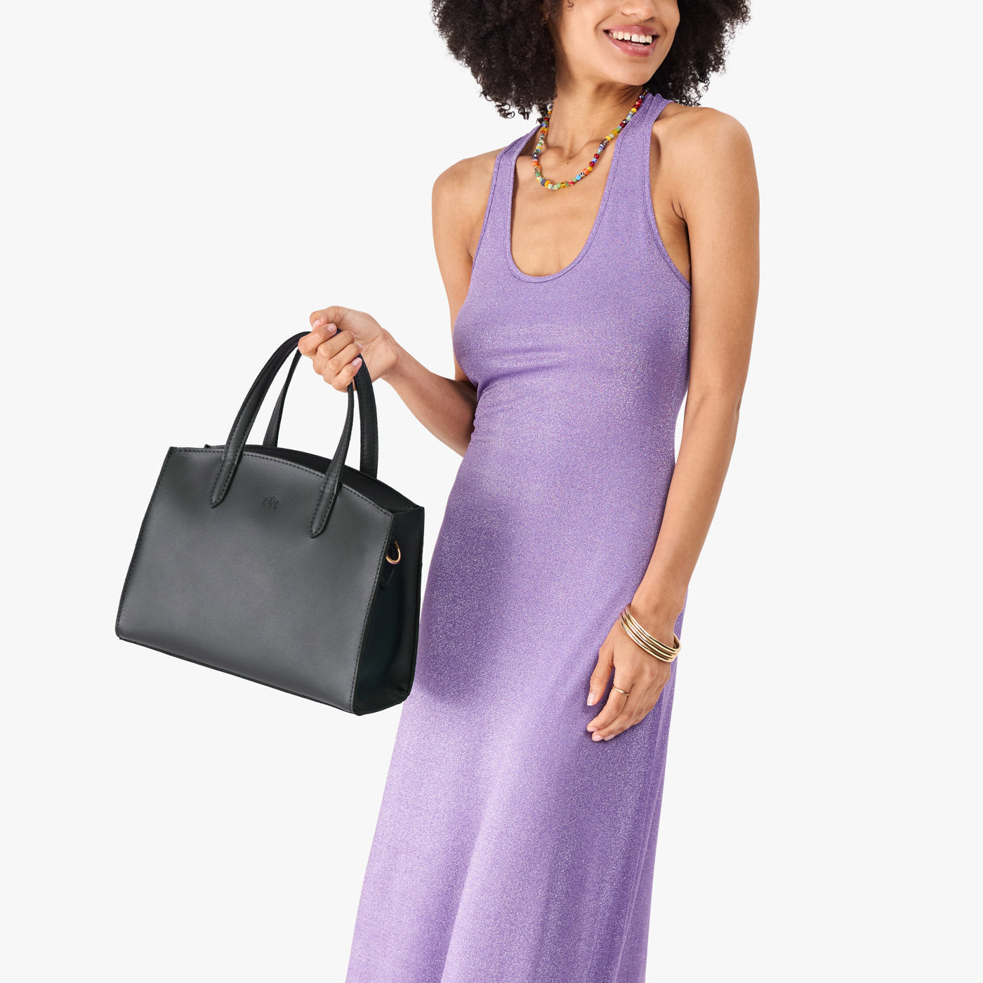 Black*Medium | Model carrying leather tote bag with handles, adjustable crossbody strap, and two back pockets
