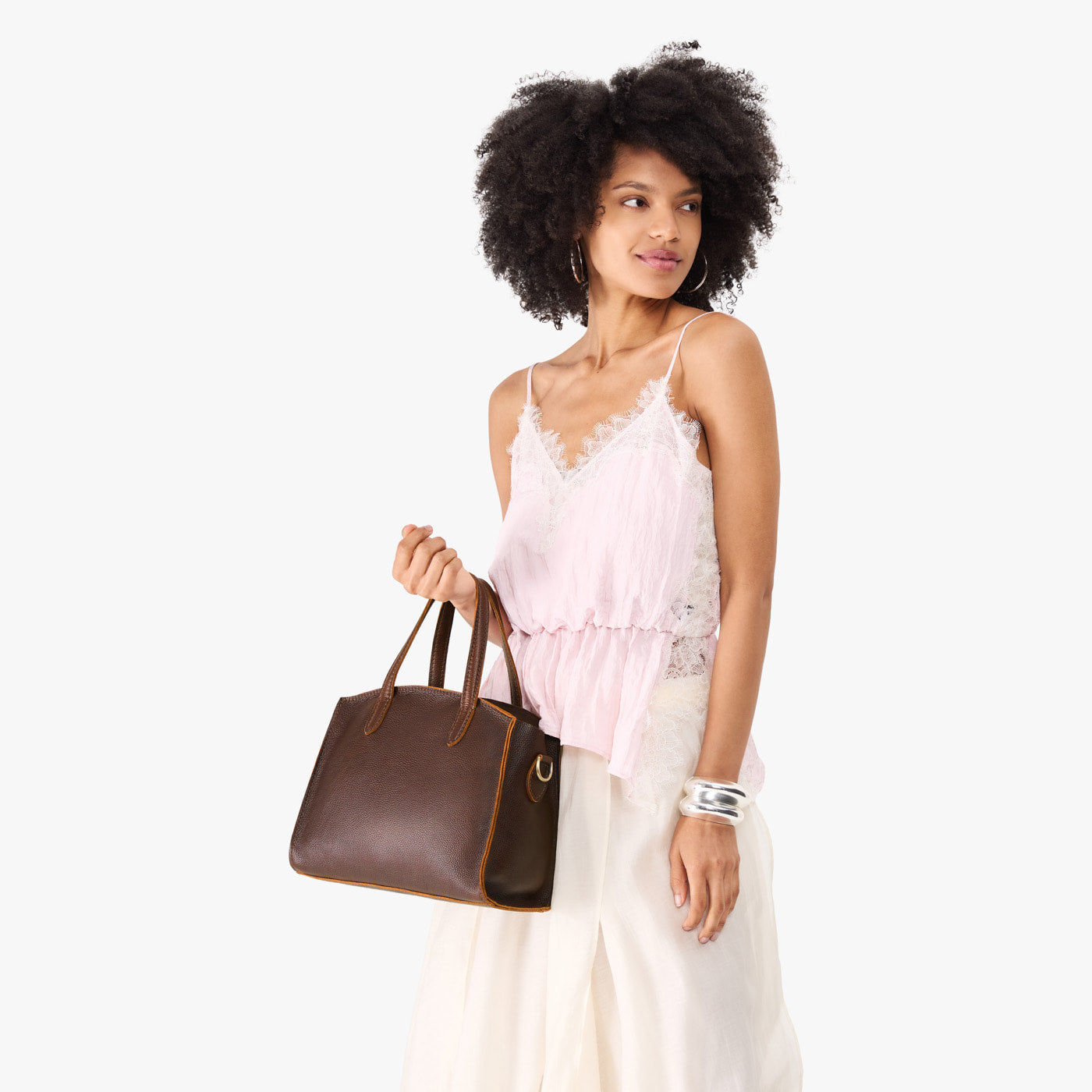 Coldbrew*Medium | Model carrying leather tote bag with handles, adjustable crossbody strap, and two back pockets