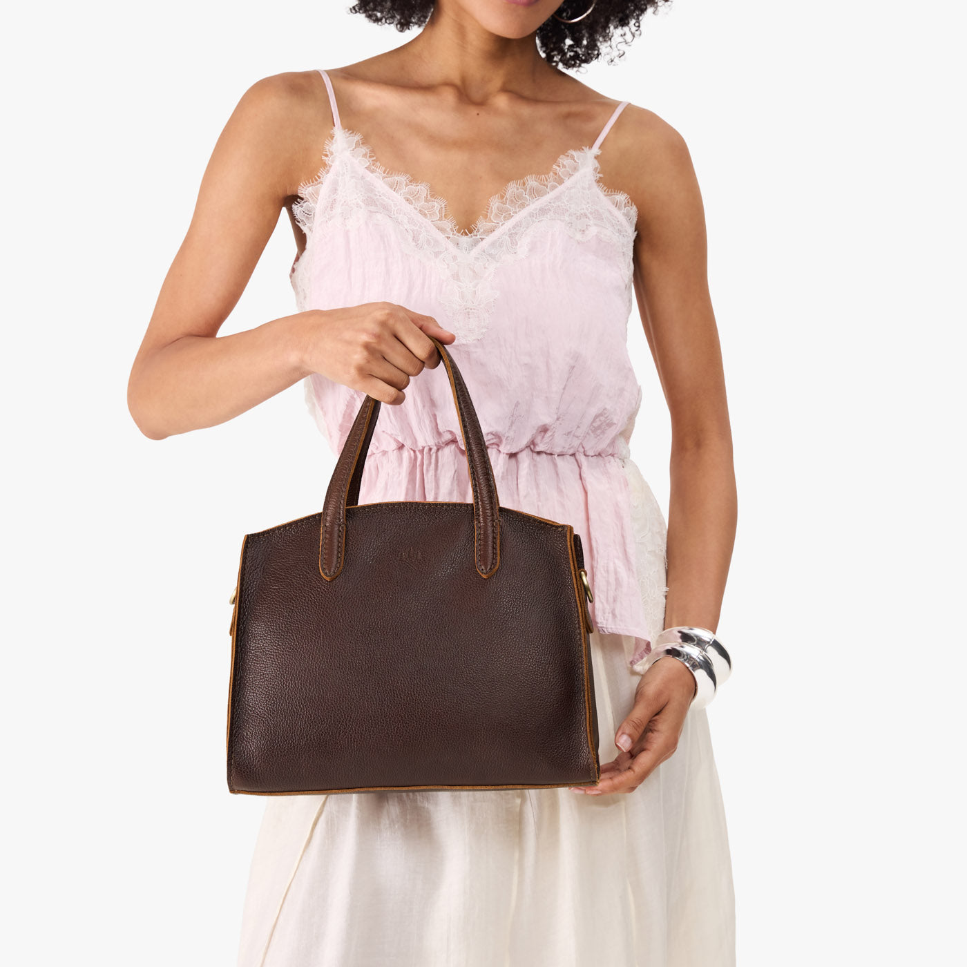 Coldbrew*Medium | Model carrying leather tote bag with handles, adjustable crossbody strap, and two back pockets
