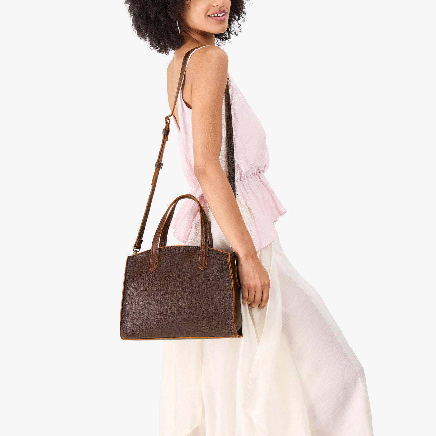 Coldbrew*Medium | Model carrying leather tote bag with handles, adjustable crossbody strap, and two back pockets