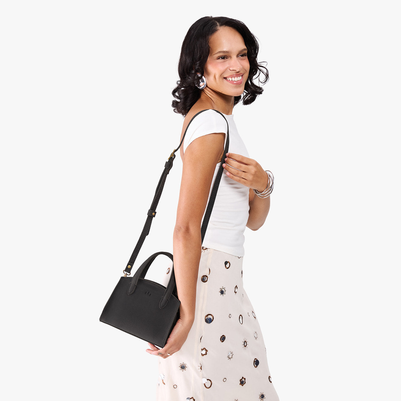 Full Moon*Mini | Model carrying small leather tote bag with handles, adjustable crossbody strap, and one back pocket