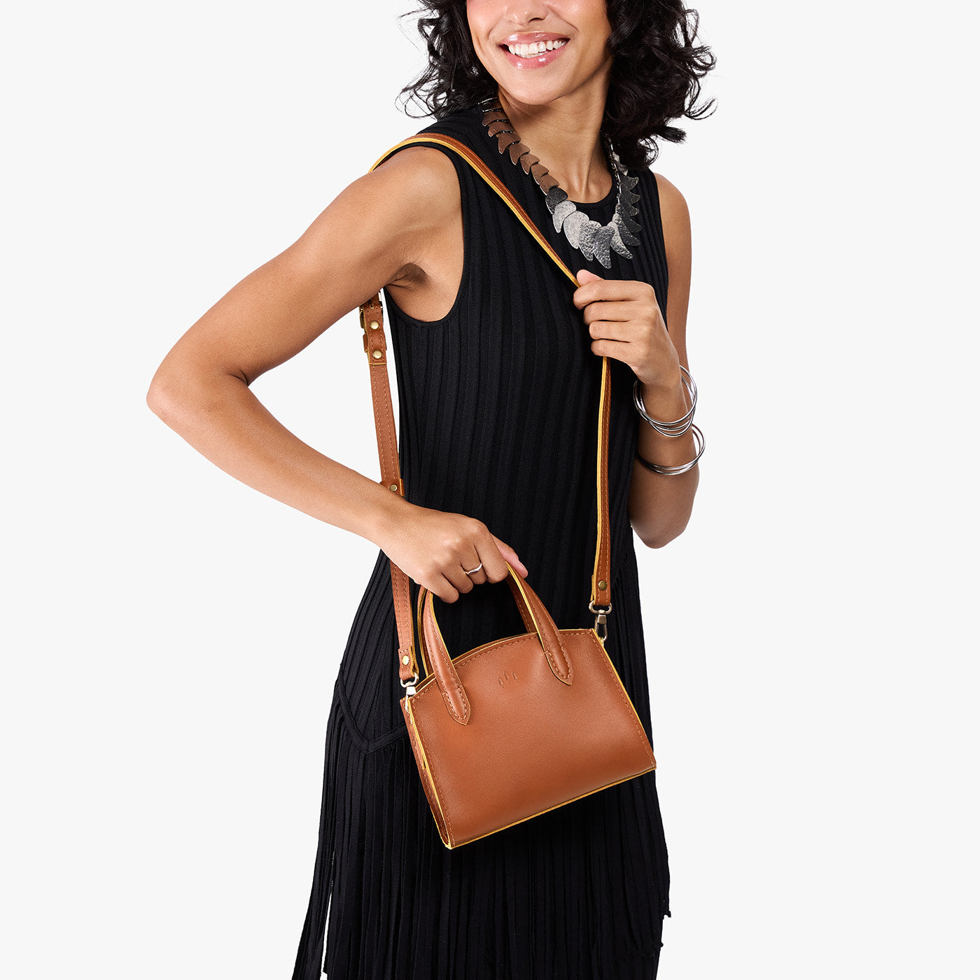 Honey*Mini | Model carrying small leather tote bag with handles, adjustable crossbody strap, and one back pocket