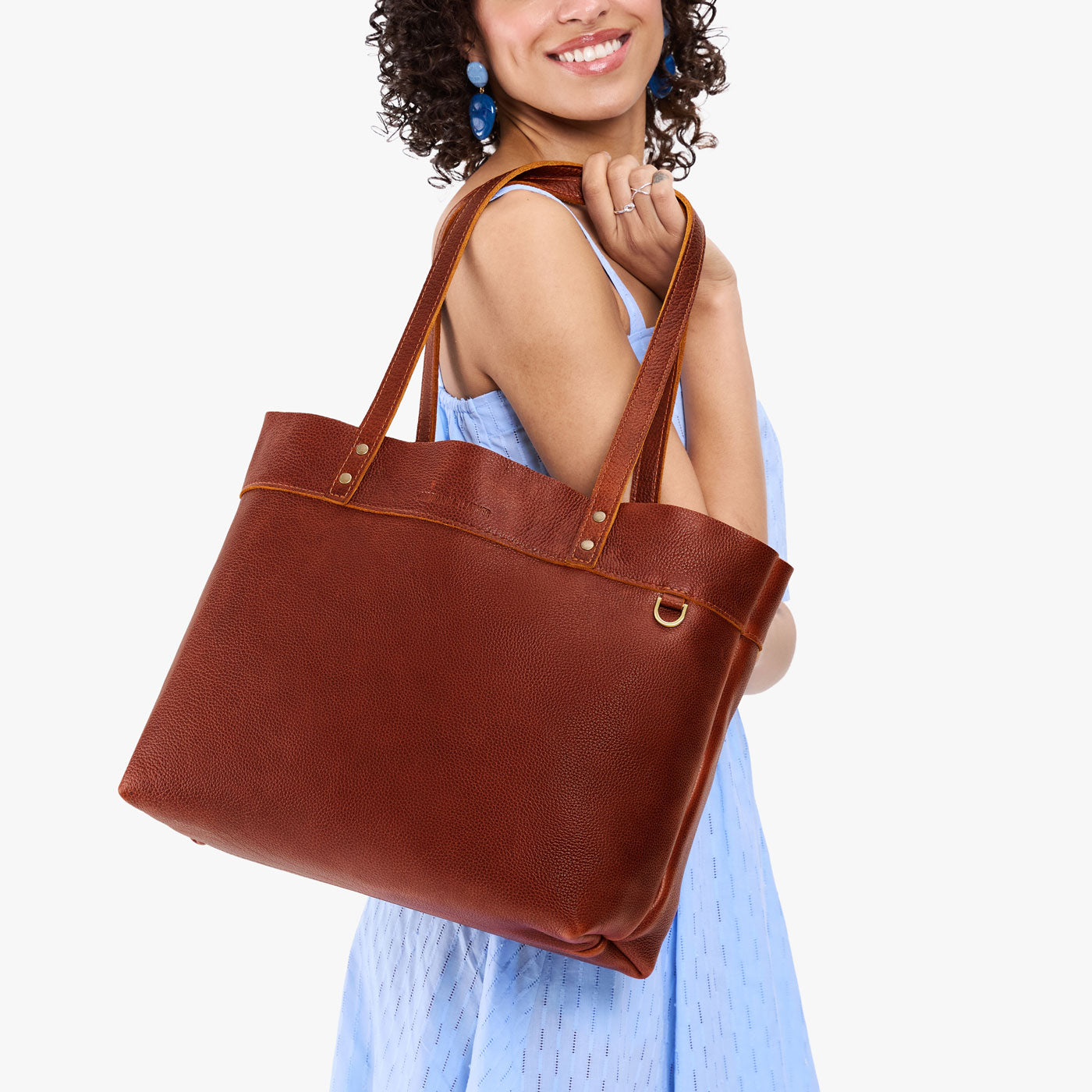 Nutmeg*Large*Classic | Model wearing leather tote bag with riveted straps and exterior key loop