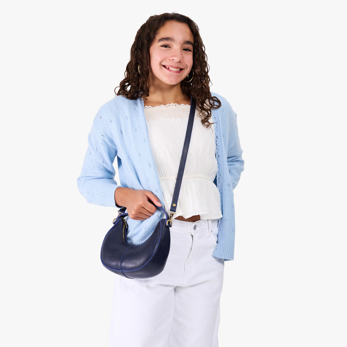 Cobalt | Model with a crescent shaped shoulder bag with zipper closure and gold accents