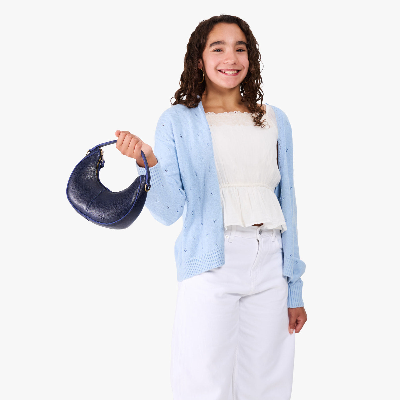 Cobalt | Model with a crescent shaped shoulder bag with zipper closure and gold accents