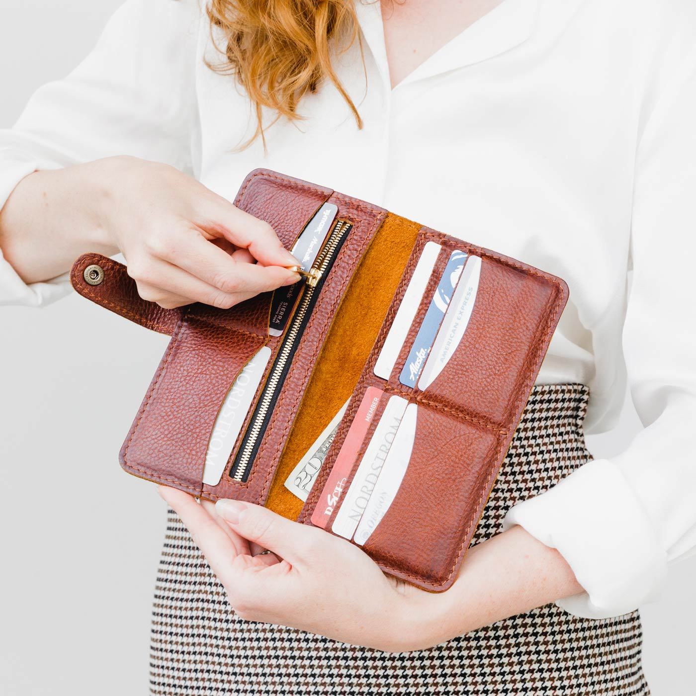 Nutmeg | Model holding leather wallet with snap open