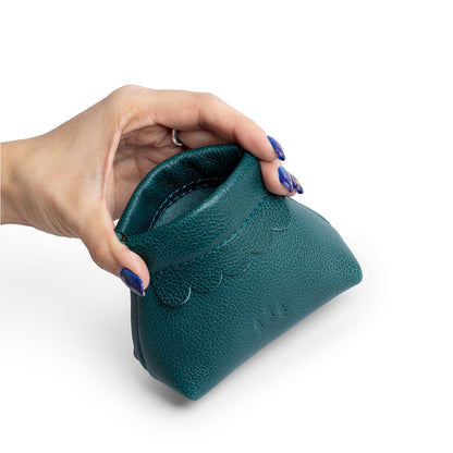 Sea Glass | Hand holding leather coin pouch with scalloped edge and three Portland leather tree emblems open