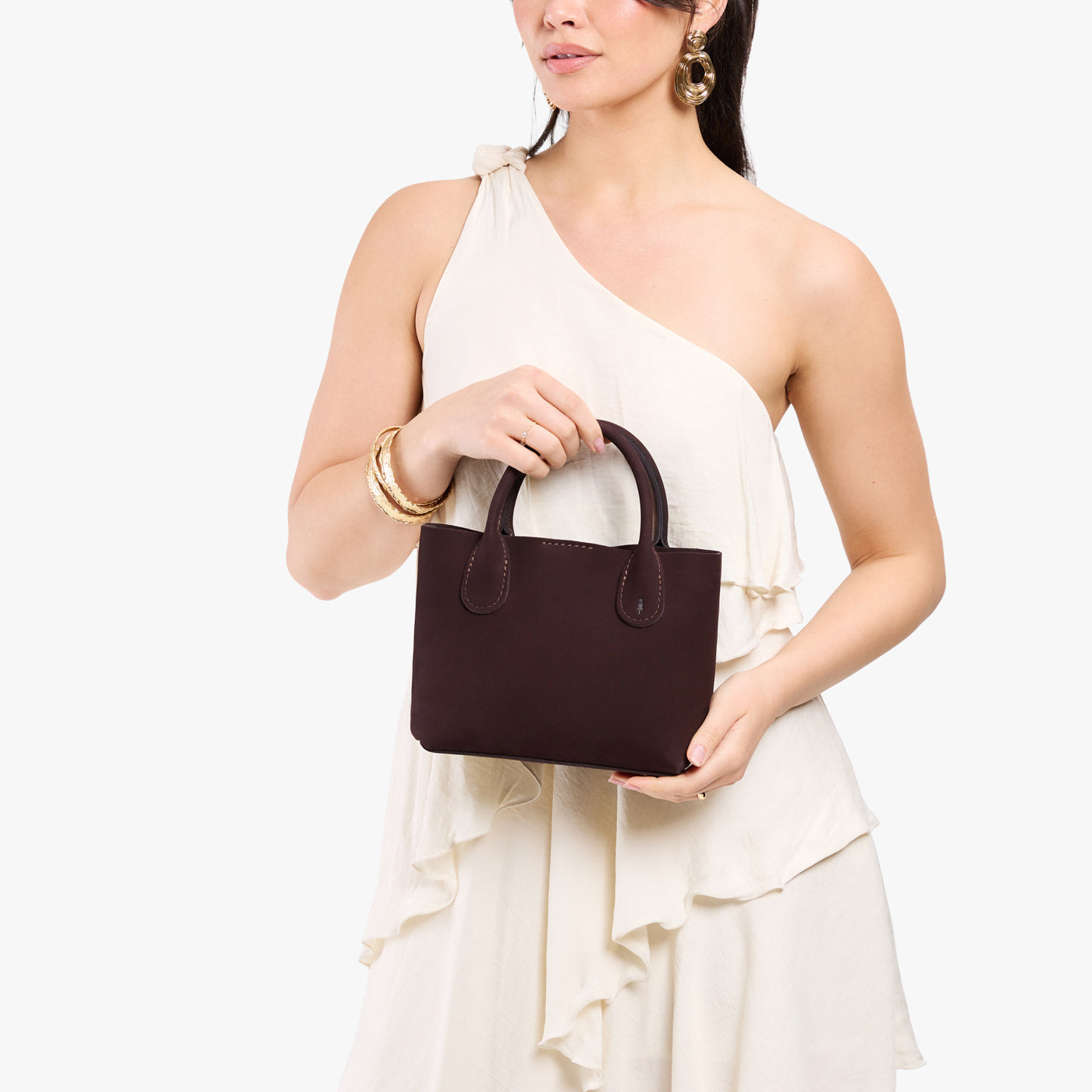 Velvet Brown*Small | Model holding petite tote purse with structured leather handles and crossbody strap
