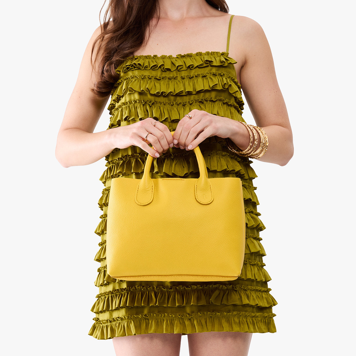 Canary*Large | Model holding a mid-size tote purse with structured leather handles and crossbody strap