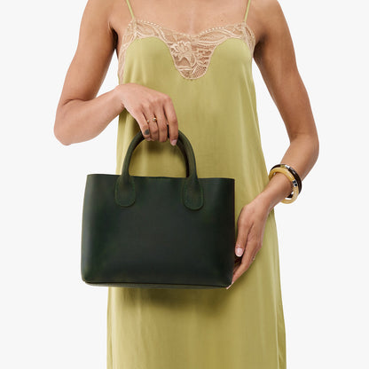 Evergreen*Large | Model wearing a mid-size tote purse with structured leather handles and crossbody strap