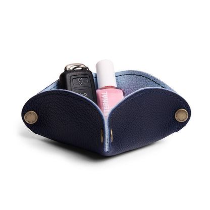 Cobalt | Square-shaped foldable leather tray with snap-button corners holding car keys and nail polish