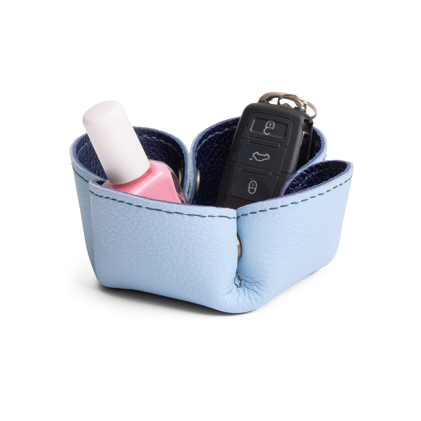 Cobalt | Clover-shaped foldable leather tray with snap-button corners holding nail polish and car keys