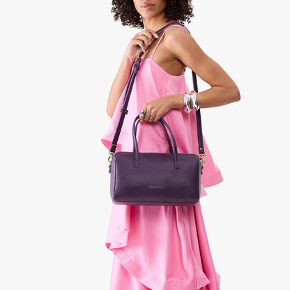 Empire*Oversized | Model holding mini duffle shaped handbag with crossbody strap