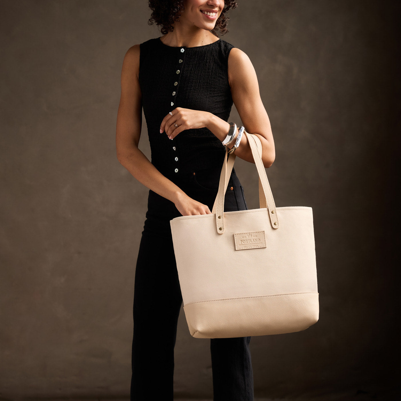 Warm Sand | Model carrying canvas tote with leather base and handles