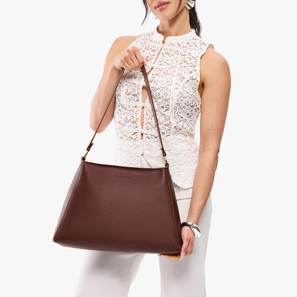 Cognac*Large | Model holding large triangular shoulder bag with antiqued brass finished hardware